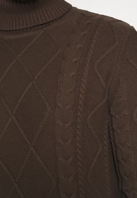 Pull marron foncé en maille torsadée avec des motifs de losanges et de corde torsadée, doté d'un col roulé côtelé.