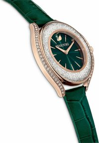 Grüne Lederarmbanduhr mit einem runden, roségoldenen Gehäuse und einem funkelnden Kristallring. Verfügt über ein dunkelgrünes Zifferblatt und goldene Stundenmarkierungen.