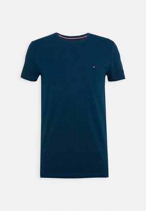 Marineblaue Baumwoll-T-Shirt mit Rundhalsausschnitt, kurzen Ärmeln und kleinem Logo. Verfügt über einen kontrastierenden, gestreiften Saum am Ausschnitt.