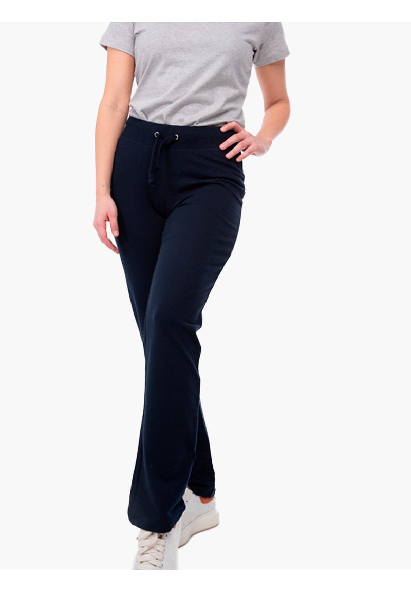 Marineblaue Jogginghosen mit elastischem Bund und Kordelzug, aus weichem Stoff. Tragen mit einem grauen T-Shirt und weißen Turnschuhen.