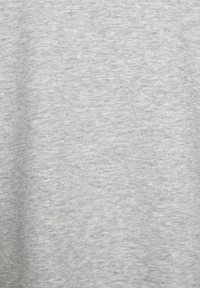 Svijetlosiva tkanina s heathered teksturom, koja pokazuje meki, glatki izgled. Materijal je vjerojatno pamuk ili mješavina pamuka, ravnomjerno tkan.