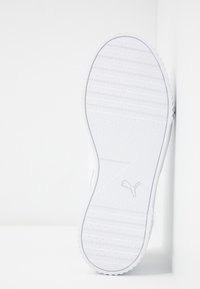 Semelle de chaussure de sport blanche en caoutchouc avec motif d'adhérence texturé, comportant un logo discret. Bords lisses et design du talon arrondi.