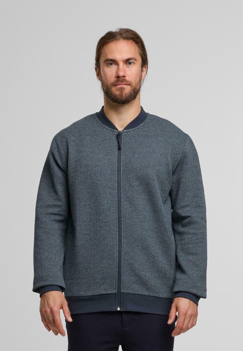 Dunkelblaue Zip-Jacke aus strukturiertem Stoff, mit Rundhalsausschnitt und langen Ärmeln. Verfügt über einen einfarbigen, marineblauen Rippkragen und Rippbündchen.