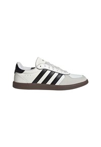 White athletic shoe with black stripes and a brown rubber sole. Made of textured leather and synthetic materials, featuring a padded collar and lace-up design.
