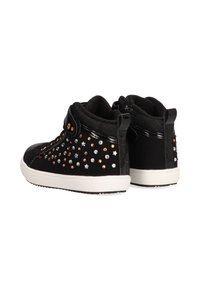 Zapatillas altas negras con textura suave, decoradas con tachuelas en plata, oro y oro rosa, y una suela de goma blanca.