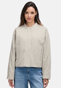 Hellgraue, verkürzte Jacke aus strukturiertem Stoff mit Stehkragen, Seitentaschen und geradem Schnitt.