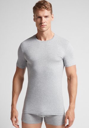 Szary t-shirt z krótkim rękawem wykonany z miękkiego, elastycznego materiału, z okrągłym dekoltem, w połączeniu z dopasowanymi szarymi szortami o przylegającym kroju.