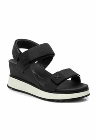Sandalias de cuña negras con correas texturizadas y suela blanca. Cuenta con correas ajustables y una plantilla acolchada para mayor comodidad.
