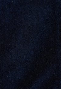 Tissu texturé bleu marine foncé avec surface douce et duveteuse et variations subtiles de teinte et de texture.