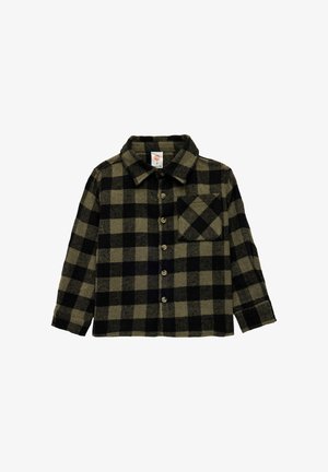 Camisa de manga larga botonada con patrón a cuadros en negro y verde oliva y bolsillo en el pecho, dispuesta sobre un fondo blanco.