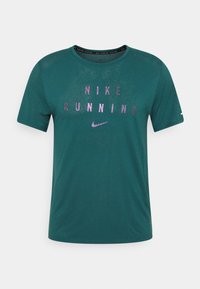 Teal short-sleeve Nike running t-shirt features reflective purple text "NIKE RUNNING" and a small logo on the left sleeve. Lightweight fabric.