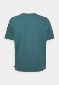 Teal short-sleeve shirt shown from the back with a horizontal seam across the upper back and plain design.