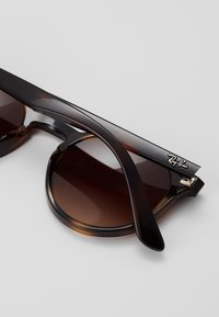 Ray-Ban solbriller med mørkebrune gradientlinser. Ramme i skilpaddeacetat med slanke svarte stenger som har detaljer med sølvlogo.