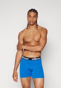 Blaue Boxershorts mit einem schwarzen, markierten Bund. Hergestellt aus einem glatten, dehnbaren Stoff mit einer enganliegenden Passform und ohne sichtbare Muster oder Akzente.