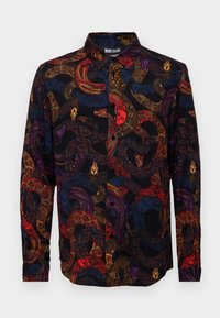 Camicia con bottoni in tessuto nero con un motivo colorato di serpenti e volti in rosso, viola e oro. Design con colletto e bottoni.