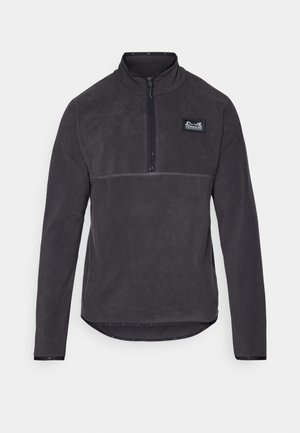 Fleece pullover in dark gray with a quarter-zip collar, stitched detailing, and a logo patch on the left chest. Smooth texture.