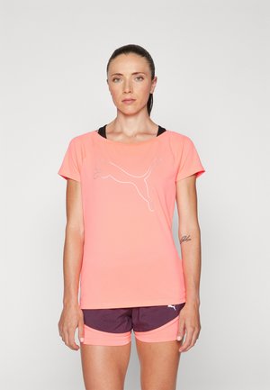 Short-sleeve athletic t-shirt in bright coral, featuring a reflective white Puma logo on the front, paired with dark purple athletic shorts.