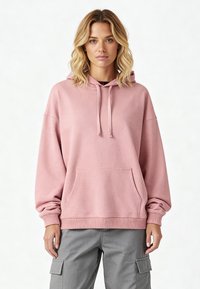 Felpa rosa chiaro con tasca anteriore, cappuccio con cordino e polsini e orlo a costine. Realizzata in un tessuto morbido e testurizzato.