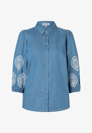 Blue denim blouse with button front, long puffed sleeves, elastic cuffs, and white embroidered patterns on sleeves.