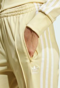 adidas Originals ADICOLOR CLASSICS FIREBIRD TRACK - Teplákové kalhoty - powder yellow