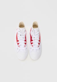 Υψηλές πάνινες αθλητικές μπότες με λευκό σώμα και κόκκινες πλευρικές πάνελ, λευκά κορδόνια, ασημένιες τρύπες κορδονιών και υφασμένο λαστιχένιο πέλμα.