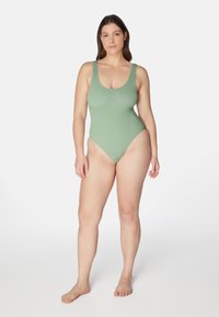 Ribbade baddräkten i mjuk salviagrön. Har breda axelremmar, rundad halsringning och högskurna ben för minimal täckning.