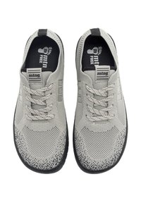 Ein Paar graue, gestrickte Sportschuhe mit schwarzen Sohlen und gemusterten Schnürsenkeln, von oben auf einem weißen Hintergrund betrachtet.