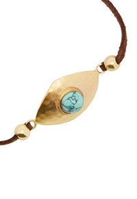 Złoty bransoletka w kształcie oka z wyżłobionym metalem, z turkusowym kamieniem w centrum oraz brązowym zamszowym sznurkiem z złotymi koralikami.