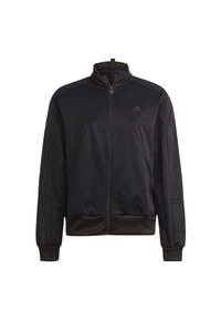 Chaqueta negra con cremallera, hecha de tejido texturizado, que presenta un cuello alto, costuras verticales y tres rayas a lo largo de los hombros.