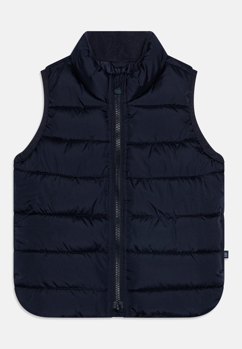 Námořnická puffer vesta s vysokým límcem, zapínáním na zip vpředu a vertikálním prošíváním. Měkká textura s zaobleným lemem a bočními panely.