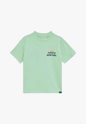 Šviesiai žalia trumpomis rankovėmis marškinėliai su apvalia iškirpte ir tamsiai mėlynu užrašu „PUERTO MONTAÑA“ po mažyčiu geltonu saulės grafiniu piešiniu kairėje krūtinės pusėje.
