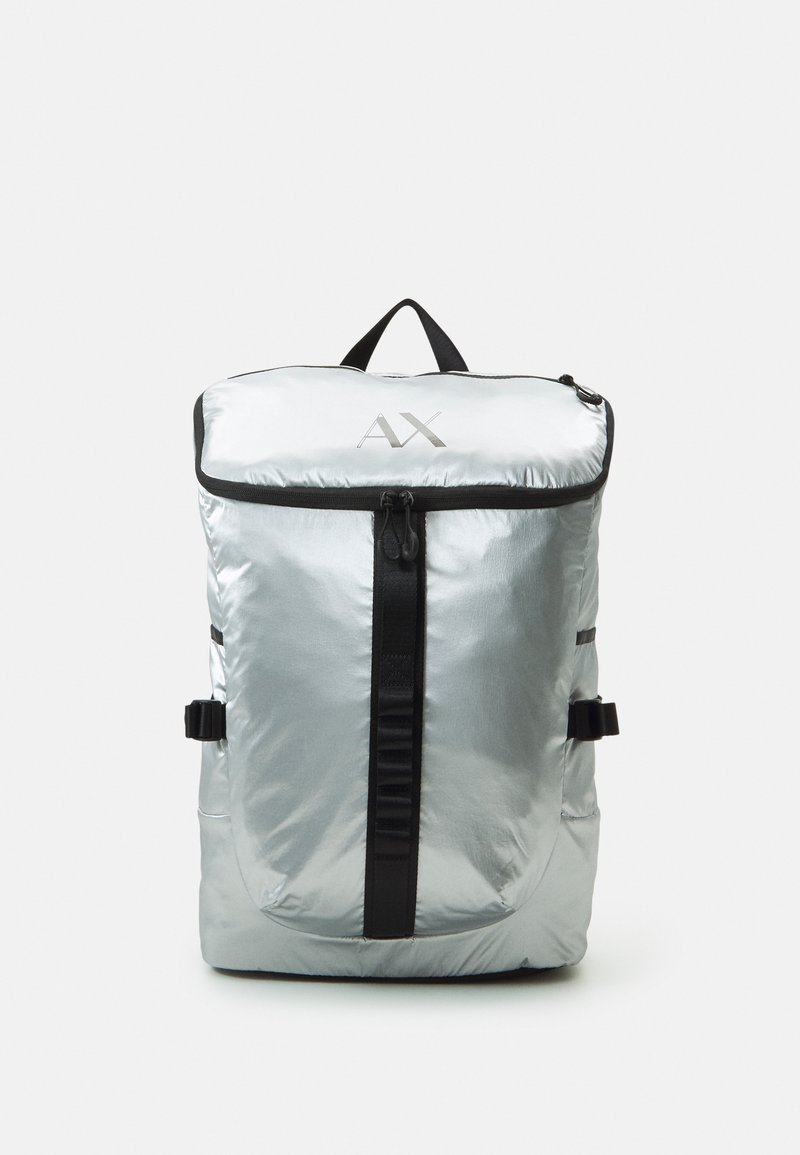 Silver men's backpack with a glossy finish, black zipper, adjustable straps, and a top handle; features a prominent logo on the front.