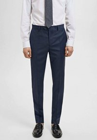 Dark blue tailored dress pants with a slim fit, subtle pinstripes, smooth texture, and a single button closure at the waist.