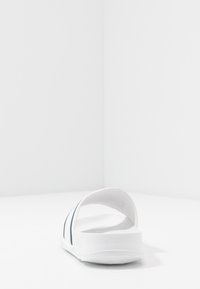 Infradito bianchi con suola testurizzata, cinturini curvi e dettagli blu scuro lungo i lati. Design semplice con retro aperto per una maggiore traspirabilità.