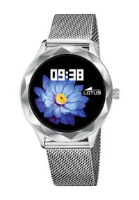 Srebrni pametni sat s okruglom, fasetiranom kućištem. Ima digitalni prikaz s cvjetnim dizajnom, koji prikazuje vrijeme 09:38 i marku "LOTUS." Remen od mrežice.