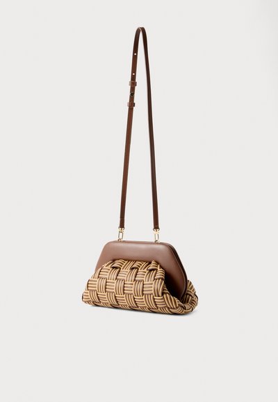 Καφέ τσάντα χιαστί από δέρμα και πλεκτό ρατάν με ρυθμιζόμενο λουρί, δομημένο πλαίσιο και στρογγυλεμένο πάτο, εμφανιζόμενη σε ουδέτερο φόντο.