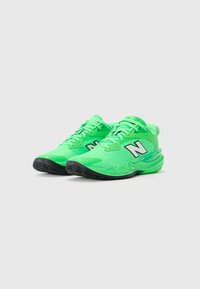 Et par lysegrønne New Balance løbesko med sorte såler og det fremtrædende hvide "N" logo, vinklet let til højre.