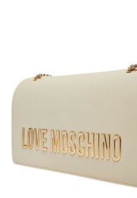 Borsa beige con una texture liscia, hardware in tono oro, logo "LOVE MOSCHINO" in rilievo e dettagli decorativi in catena.