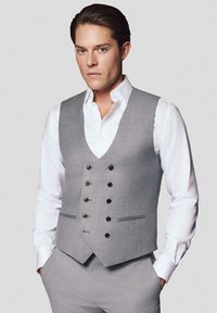 Szary kamizelka garniturowa z czarnymi guzikami, zapinana na jeden guzik, o wyraźnej formie i klapach, w połączeniu z białą koszulą.
