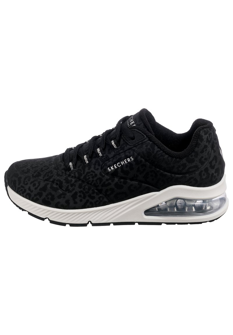 Svart sneaker med leopardmønster, semsket tekstur, hvit mellomsåle og klar luftpute i hælen, med svarte lisser og merke.