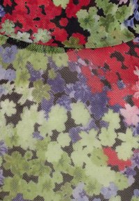 Blommig meshtyg med en blandning av röda, gröna, blå och lila blommor mot en svart bakgrund, med en lätt och semi-transparent textur.