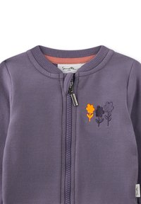 Lila Zip-Jacke mit geripptem Kragen, verziert mit gestickten Blumen in Gelb und Dunkellila. Weicher Stoff, minimalistisches Design.