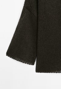 Donkerbruin gebreid sweater met een losse structuur, met brede mouwen en een ruwe zoom. Het materiaal lijkt zacht en textuur te hebben.