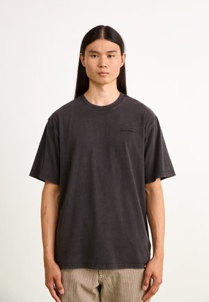 Camiseta de gran tamaño en gris oscuro con cuello redondo, mangas cortas y un logo sutil en el pecho, fabricada en suave tejido de algodón.