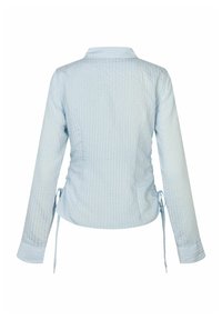 Haut à manches longues bleu clair avec un motif texturé en grille, doté d'un col et de liens sur les côtés ajustables pour une silhouette ajustée.