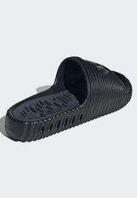 Svart flip-flop sandal med ribbat mönster, öppen tå och vadderad grå innersula med ventilationshål för andningsförmåga.
