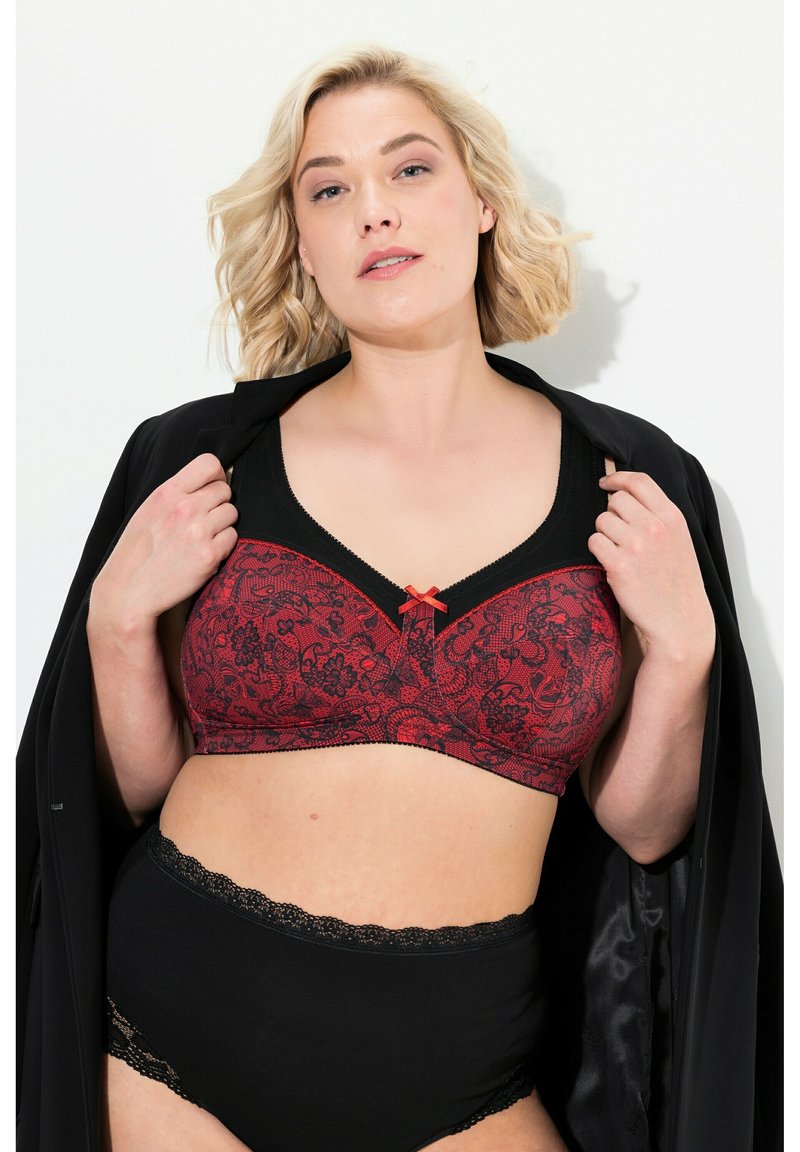 Schwarzer und roter Spitzen-Bra mit floralem Muster, ausgestattet mit einer Schleifenakzent und schwarzem Rand. Hochgeschnittene schwarze Panties mit Spitzen-Details.