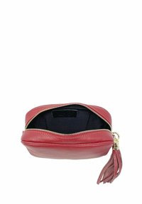 Pochette rossa in pelle dalla forma rotonda con cerniera dorata, con un interno nero e un dettaglio a nappina sul lato.