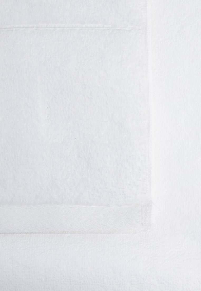 Weißes Frotteehandtuch mit einer weichen, strukturierten Oberfläche. Verfügt über einen genähten Rand und einen glatten, einfarbigen Bereich. Das Gesamtdesign ist einfach und funktional.