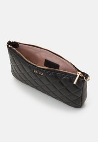 Bolsa tipo pouch de cuero negro acolchado con cremallera dorada y herrajes en dorado. La tela es suave y tiene un forro interior blando. Presenta el logo de la marca en el exterior.
